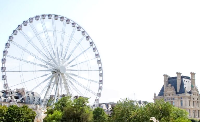 A giant Ferris wheel towering above trees near the Louvre, with the historic museum building visible in the background. Kids and families can enjoy the charm of this area while strolling through nearby gardens.