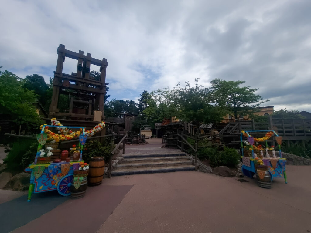 Colorful carts and rustic props fill a lively Frontierland market zone near Thunder Mesa, styled like an Old West mining camp.