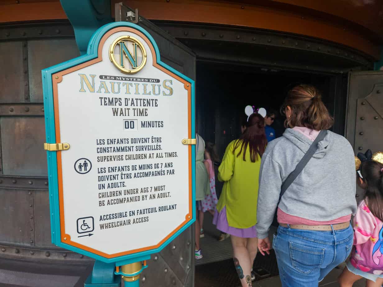Guests enter "Les Mystères du Nautilus" with a sign showing 00-minute wait time and multilingual safety information — a quiet gem among disneyland paris secrets.