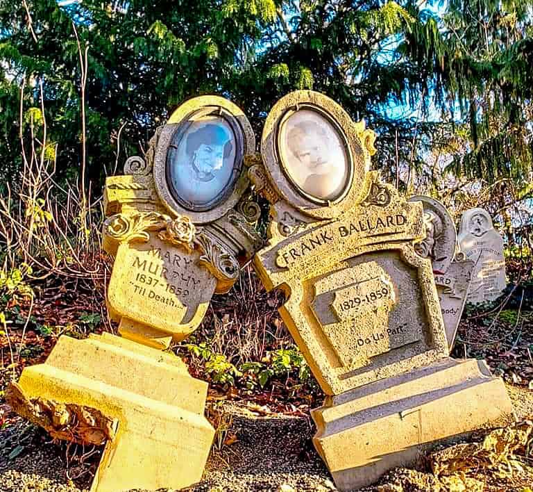 Two weathered gravestones labeled “Mary Murphy” and “Frank Ballard” lean toward each other romantically, with humorous inscriptions — a quirky photo spot outside Phantom Manor.