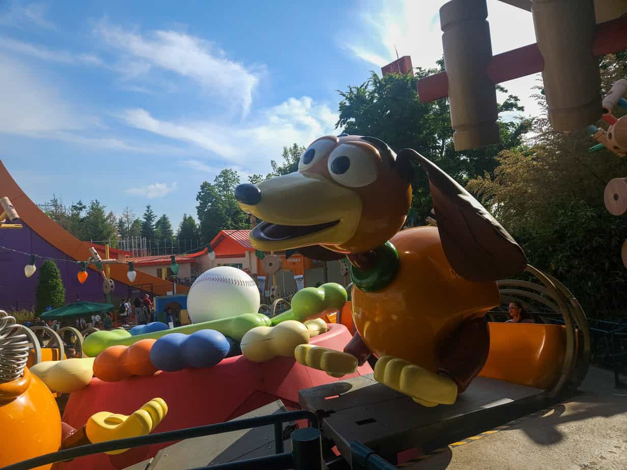 A colorful view of the Slinky Dog Zigzag Spin ride, a standout attraction that’s part of the Disneyland Paris Toy Story experience, featuring a giant Slinky Dog surrounded by oversized toy props.