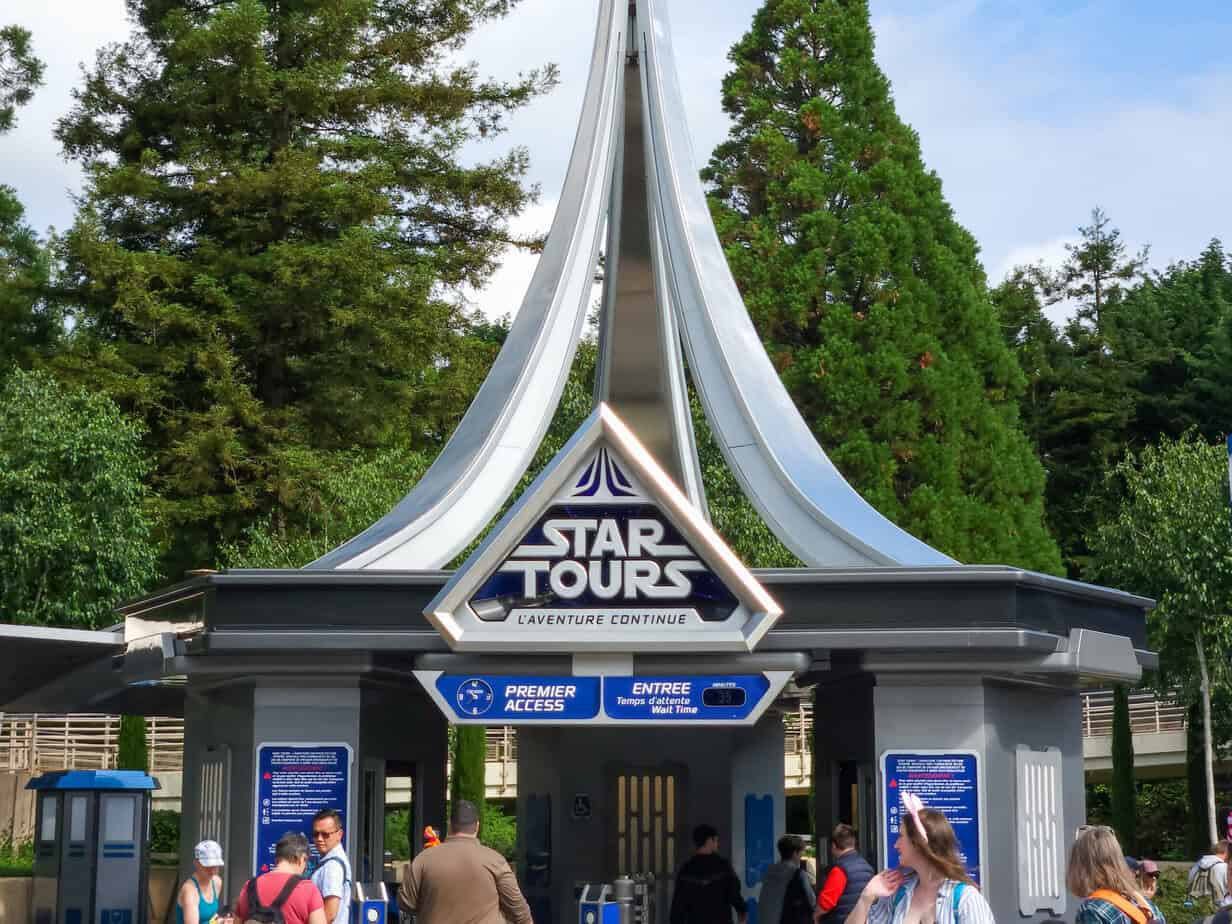 The sleek, silver and blue facade of Star Tours at Disneyland Paris welcomes guests to a Star Wars-themed adventure, with clearly marked lines for Disneyland Paris Premier Access.