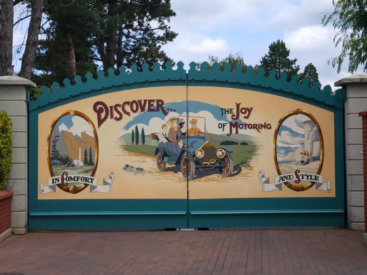 Vintage-style gate at Disneyland Paris reading “Discover the Joy of Motoring” on a one day visit.