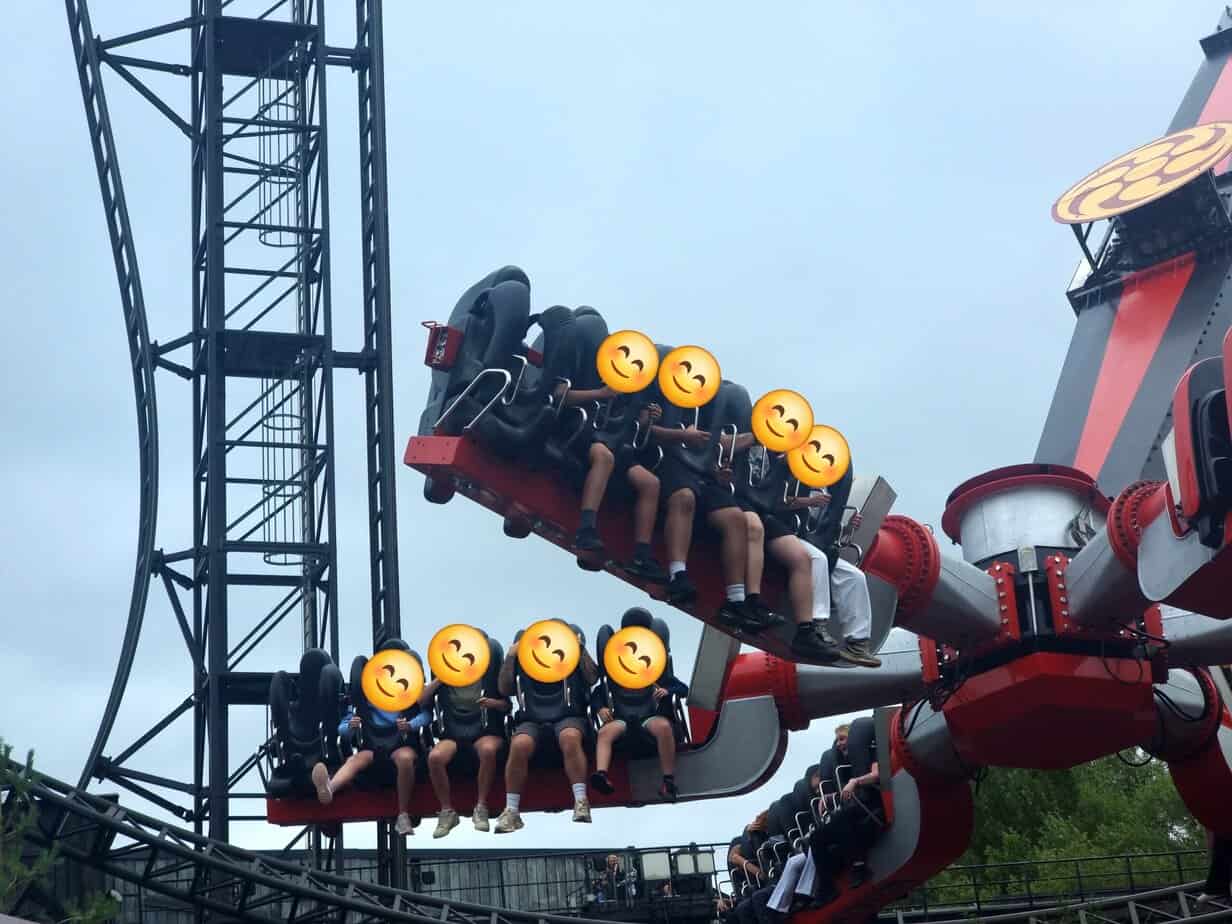 Riders are lifted and rotated mid-air on the Samurai ride, a red and black spinning thrill attraction with legs dangling freely. The ride’s mechanical arms extend outward, giving guests a gravity-defying experience.