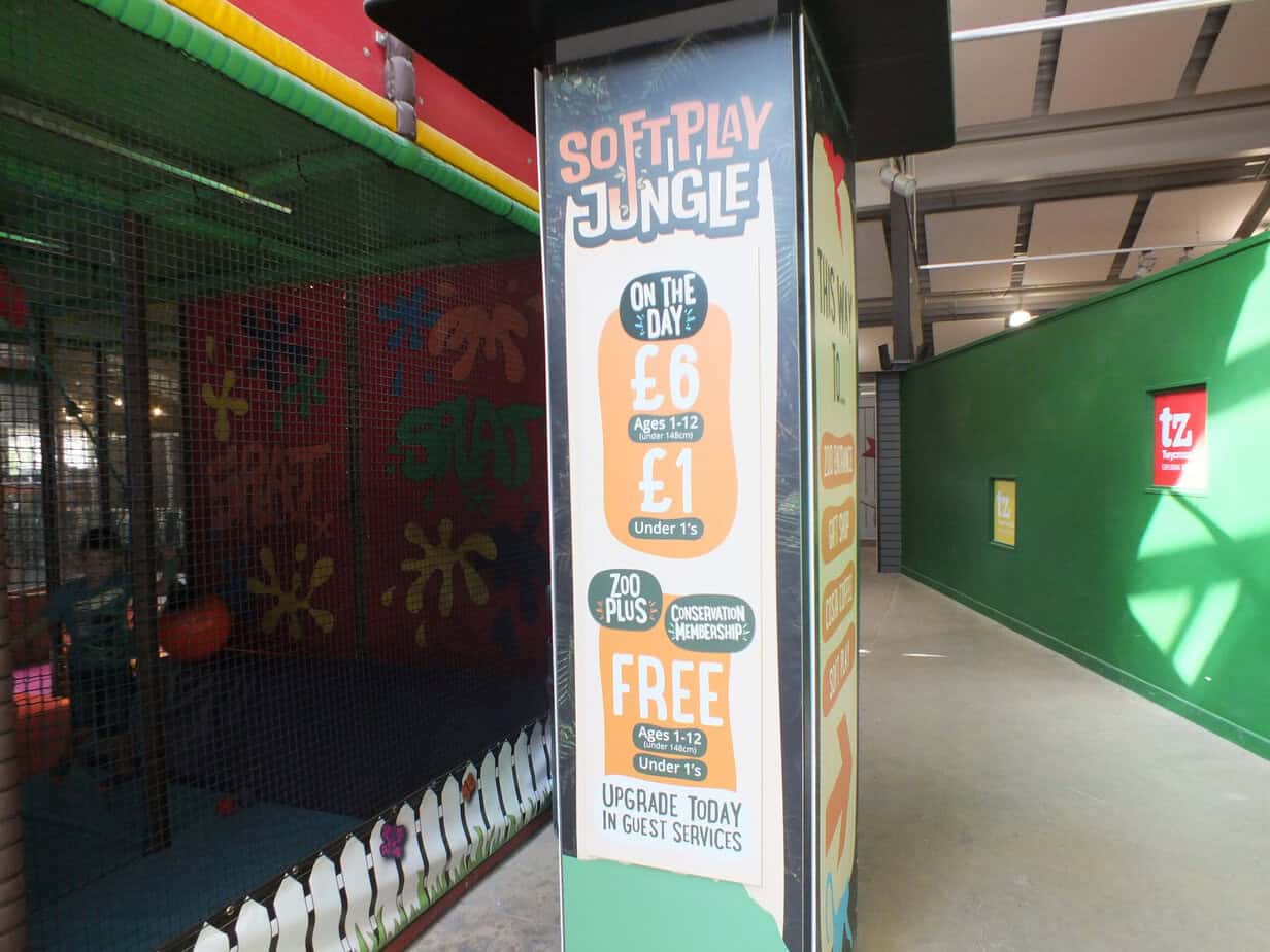 Soft play area at Twycross Zoo beside a sign reading "SOFT PLAY JUNGLE". The pricing sign reads "ON THE DAY £6 Ages 1.12 under 145cm £1 Under 1s ZOO PLUS CONSERVATION MEMBERSHIP FREE Ages 1.12 under 145cm Under 1s UPGRADE TODAY IN GUEST SERVICES".